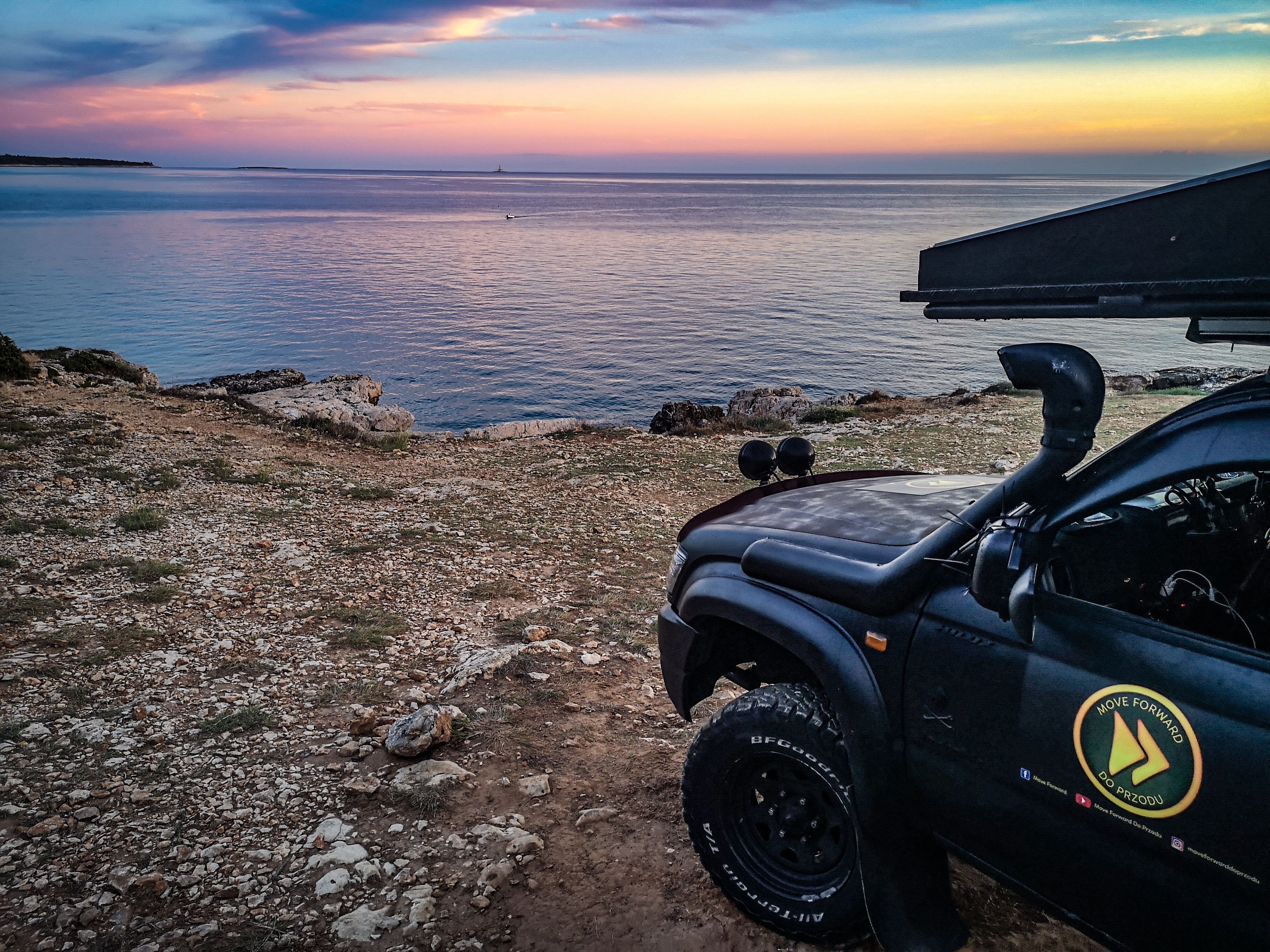 Zachód słonca nad morzem. Samochód terenowy nad morzem, obozowanie na dziko w Chorwacji 
Sunrise, 4x4 truck by the sea in Croatia, wild camping.